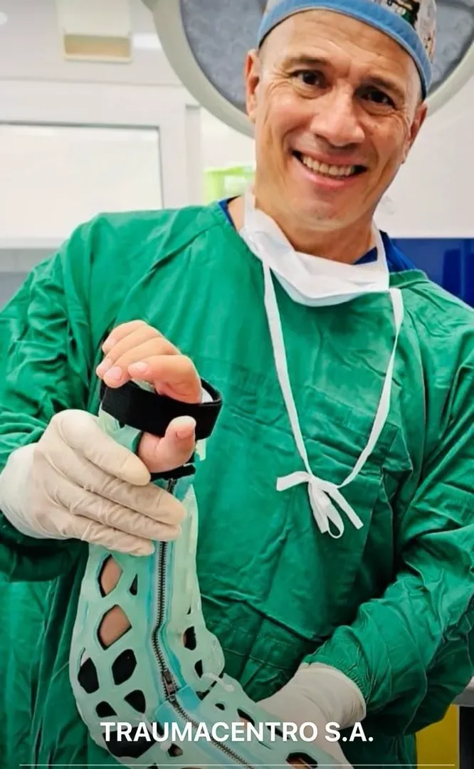 A surgeon in theatre holding an uncured FlexiOH full arm lattice, ready to apply
