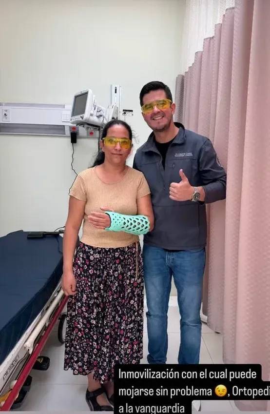 A patient wearing a FlexiOH immobilizer standing with her surgeon in a clinic