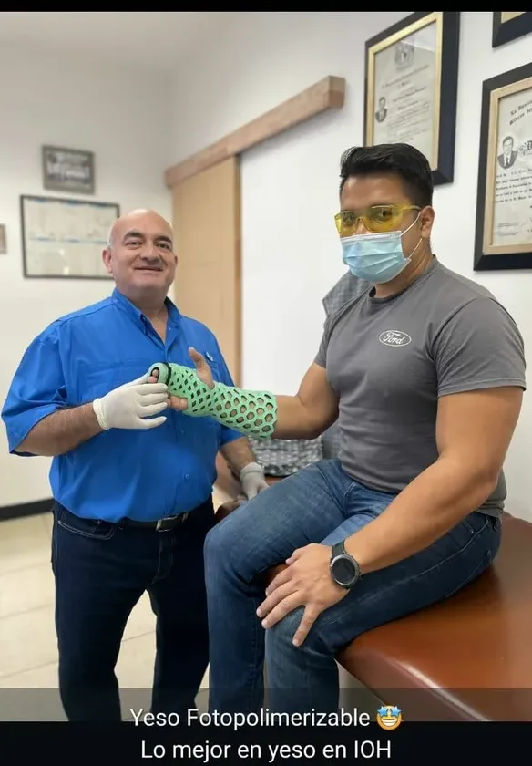A clinician handing a FlexiOH immobilizer to a patient in a consulting room