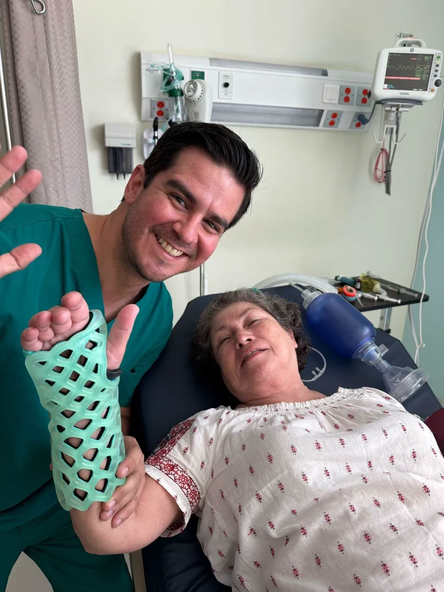 A clinician holding up a patient's arm in a cured FlexiOH short arm immobilizer