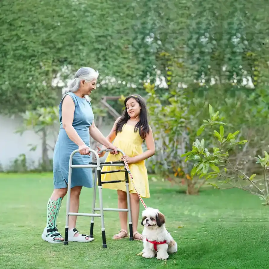 Grandmother with a walker and granddaughter, both wearing FlexiOH immobilizers