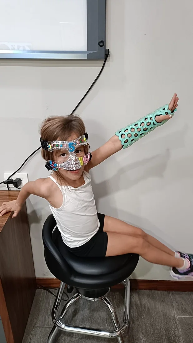 A girl wearing a FlexiOH arm immobilizer