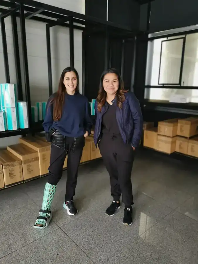 Two women, one wearing a FlexiOH short leg immobilizer